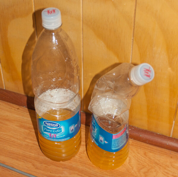 Zwei PET-Flaschen, eine zerdrückt vom Luftdruck