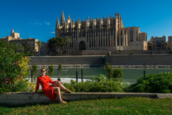 Frau im roten Kleid vor der Kirche von Palma de Mallorca
