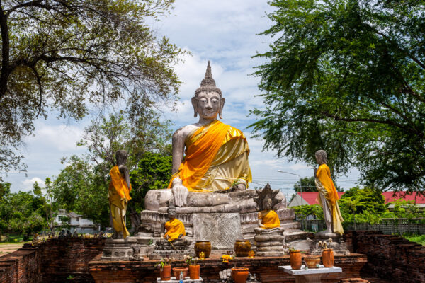 Buddhastatuen, die orange Tücher tragen