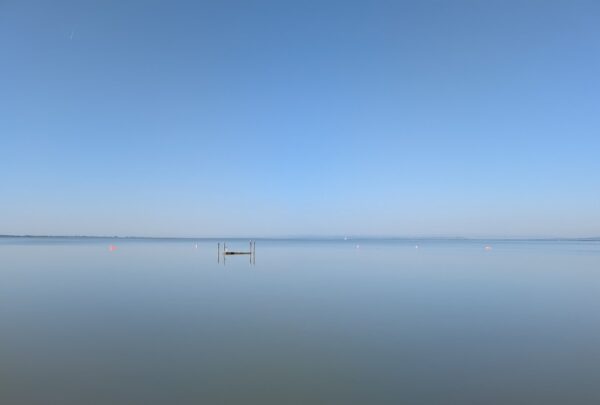 Der Neusiedler See ist spiegelglatt am Morgen