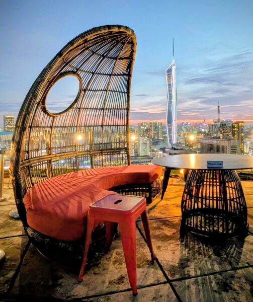 Eine Ratansitzgruppe auf dem Dach eines Wolkenkratzers in der Dämmerung