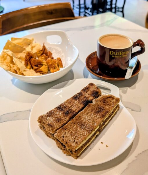 Ein Ipoh White Coffee und ein Teller mit Toast, Butter und Kaya